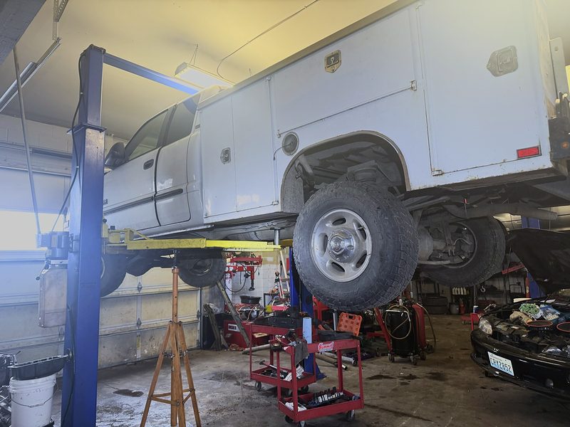 Work truck with a utility bed up on a lift for repair